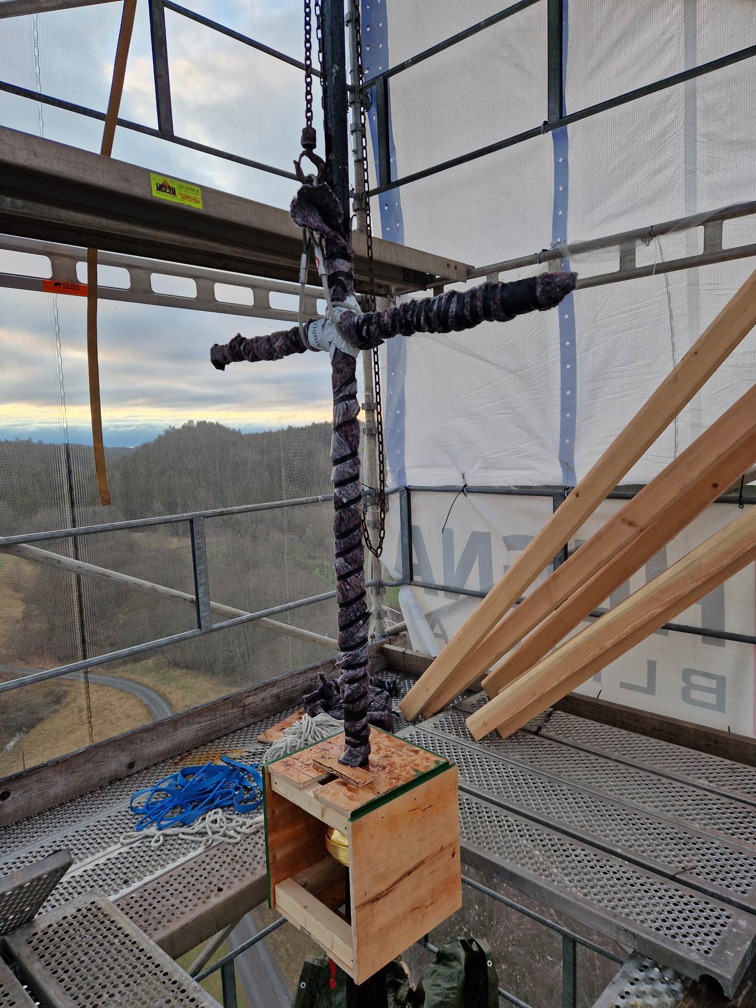 Nyrenovert og fortsatt innpakket kors i toppen av spiret.