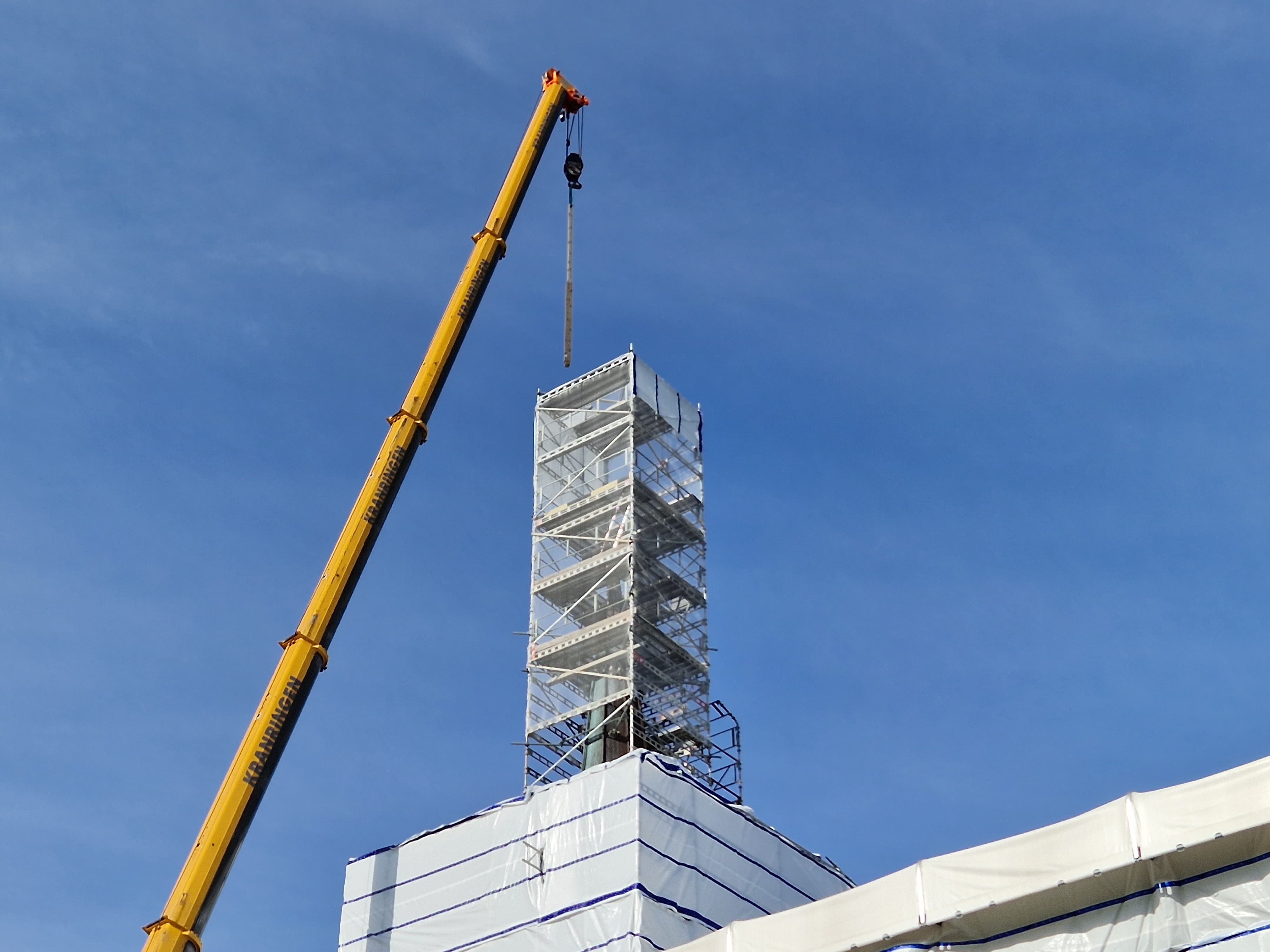 Heisekranarm i toppen av kirketårnet.